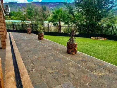 a patio with three potted plants in a yard at Valozone70 Guesthouse in Thabazimbi