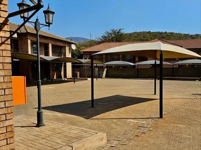 a group of umbrellas in front of a building at Valozone70 Guesthouse in Thabazimbi