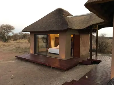 a small house with a bed and a roof at Kudu Lodge in Kromdraai