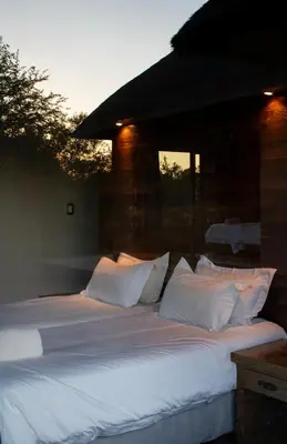 a large white bed with white pillows on it at Kudu Lodge in Kromdraai