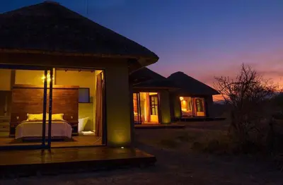 a hotel room with a bed in the middle at Kudu Lodge in Kromdraai