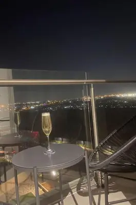 a glass of wine sitting on a table on a balcony at Ellipse Waterfall luxurious unit in Midrand