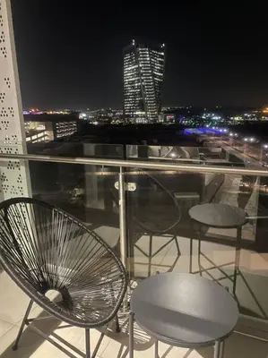 a balcony with chairs and a view of a city at night at Ellipse Waterfall luxurious unit in Midrand