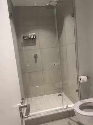 a shower with a glass door next to a toilet at Ellipse Waterfall luxurious unit in Midrand