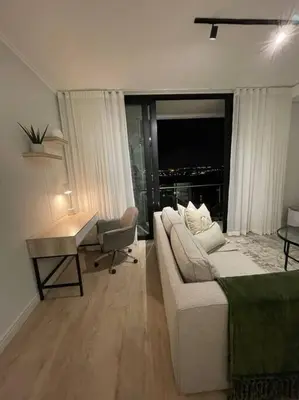 a living room with a couch and a table and a desk at Ellipse Waterfall luxurious unit in Midrand