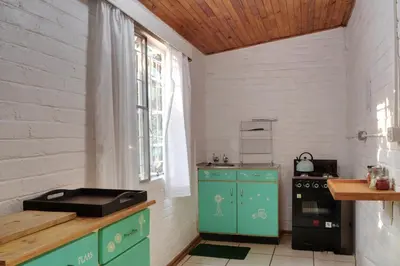 a kitchen with green cabinets and a stove at Oppi Plaas in Hazyview