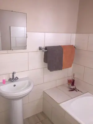 a white bathroom with a sink and a mirror at Oppi Plaas in Hazyview
