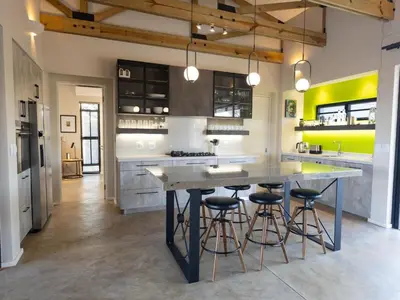 a kitchen with a large island with bar stools at Lavish villa in Hoedspruit with hot tub in Hoedspruit