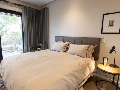 a bedroom with a large bed with a large window at Lavish villa in Hoedspruit with hot tub in Hoedspruit