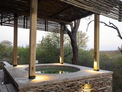 an outdoor pool with a wooden pergola with lights at Lavish villa in Hoedspruit with hot tub in Hoedspruit