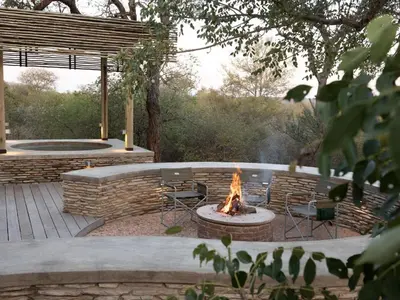 a fire pit in a yard with chairs and a fire pit at Lavish villa in Hoedspruit with hot tub in Hoedspruit