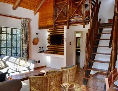 a living room with a spiral staircase in a house at Luxury Lodge on Sabie River at Kruger Gate! in Huntingdon