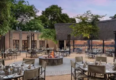 a courtyard with tables and chairs and a fire pit at Luxury Lodge on Sabie River at Kruger Gate! in Huntingdon