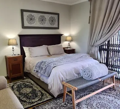 a bedroom with a bed and a chair and a window at Upstairs R-2 Self-Catering Unit in White River