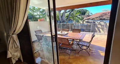 a dining room with a table and chairs on a patio at Upstairs R-2 Self-Catering Unit in White River