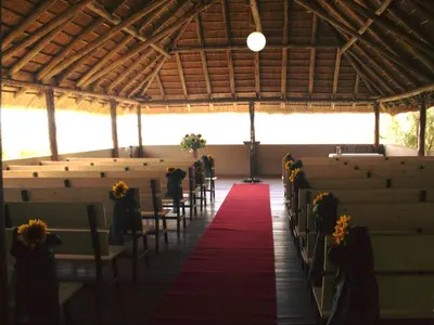 a row of tables and chairs in a barn at Motozi Lodge in Pelindaba
