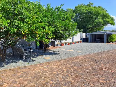 a park with a bench and trees on a sidewalk at Sleep 'n Go Guesthouse in Mokopane