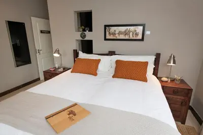 a bedroom with a white bed with a book on it at Nyaleti Lodge in Hoedspruit