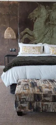 a bedroom with a large bed with a large painting at Bannockburn Guest Cottage in White River