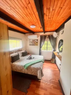 a bedroom with a bed and a wooden ceiling at Bundu in Marloth Park