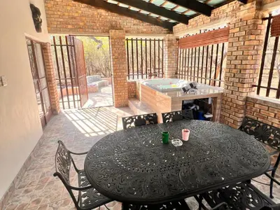 a patio with a table and chairs and a grill at Bundu in Marloth Park