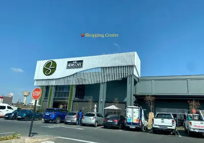 a parking lot with cars parked in front of a shopping center at Dubai 2 in Midrand