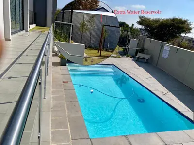 a swimming pool on the side of a house at Dubai 2 in Midrand