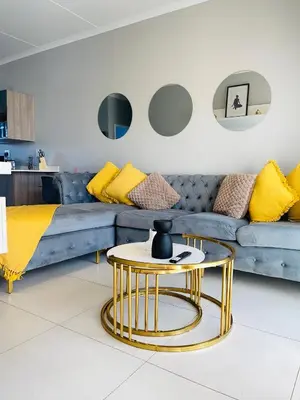 a living room with a blue couch and a gold table at Dubai 2 in Midrand