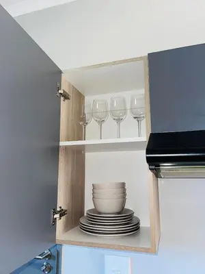 a cupboard with plates and wine glasses in it at Dubai in Midrand