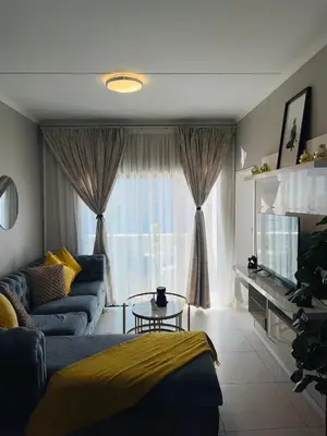 a living room with a couch and a table in front of a window at Dubai in Midrand