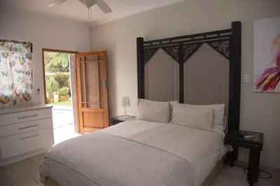 a bedroom with a large bed with a wooden headboard at Xaviera Guest House in Pretoria