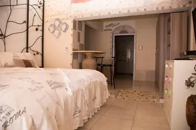 a bedroom with a bed and a table in a room at Xaviera Guest House in Pretoria