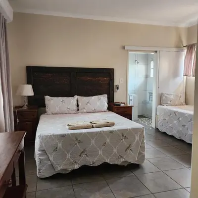 a bedroom with a bed with two towels on it at Xaviera Guest House in Pretoria