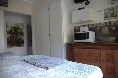 a bedroom with a bed and a microwave on a counter at Xaviera Guest House in Pretoria