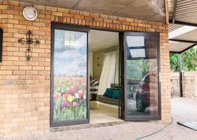 a brick house with a glass door with tulips at Stamvrug 9 B in Nelspruit