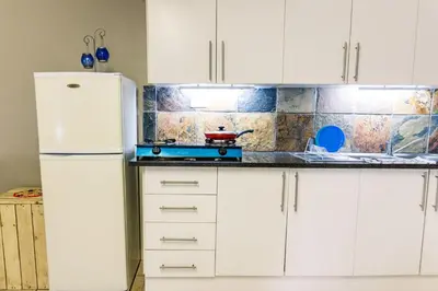 a kitchen with white cabinets and a white refrigerator at Stamvrug 9 B in Nelspruit