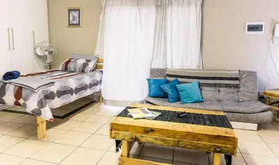 a living room with a bed and a couch at Stamvrug 9 B in Nelspruit