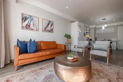 a living room with a couch and a table at STAY Menlyn in Pretoria