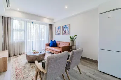 a living room with a couch and a table at STAY Menlyn in Pretoria