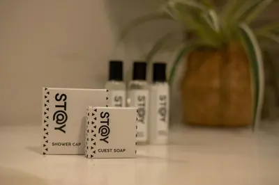 a group of three bottles ofjust soap sitting on a counter at STAY Menlyn in Pretoria