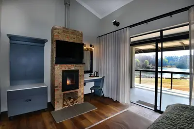 a room with a fireplace with a desk and a television at Dunkeld East in Dullstroom