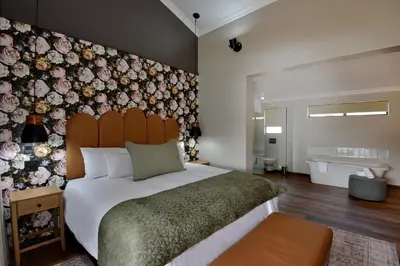 a bedroom with a large bed with a floral wall at Dunkeld East in Dullstroom