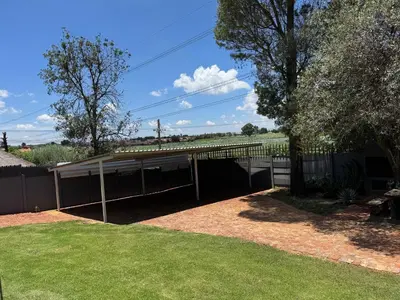 a building with awning in a yard at Spacious stay-in bachelor apartment in Kempton Park