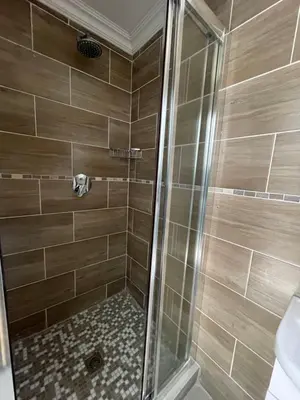a shower with a glass door in a bathroom at Spacious stay-in bachelor apartment in Kempton Park