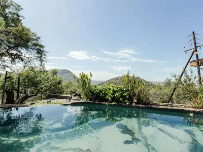 a swimming pool with a view of the mountains at Mountain Canadian Log Home in Kalkheuvel
