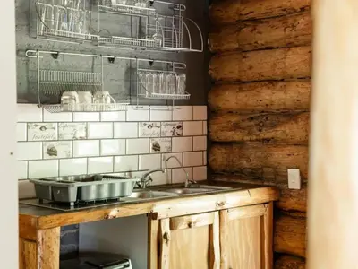 a kitchen with a sink and a wooden wall at Mountain Canadian Log Home in Kalkheuvel
