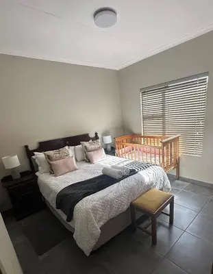 a bedroom with a large bed and a window at Lloyds - unit 10 in Ermelo