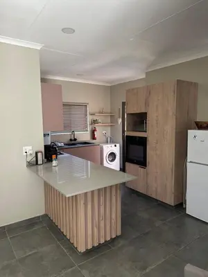 a kitchen with a counter and a white refrigerator at Lloyds - unit 10 in Ermelo