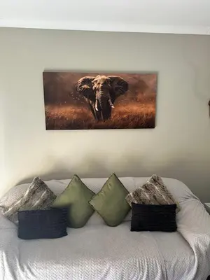 a painting of an elephant on a wall above a bed at Lloyds - unit 10 in Ermelo