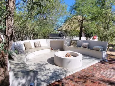 a patio with a couch and a fire pit at Taaibos Bush Lodge in Hoedspruit